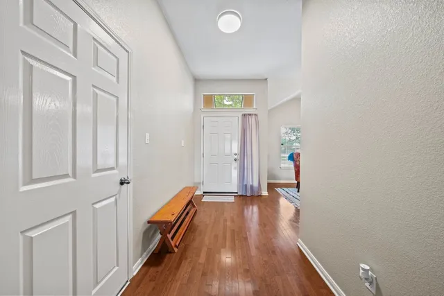 a view of a hallway with wooden floor and staircase