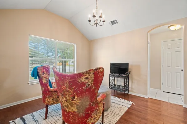 a dining room with furniture a chandelier and wooden floor