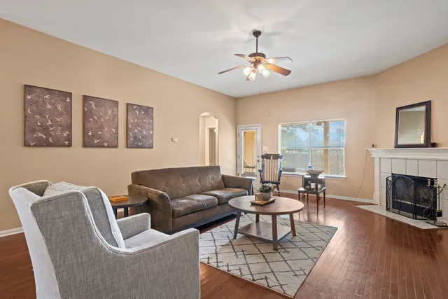 a living room with furniture a fireplace and a large window