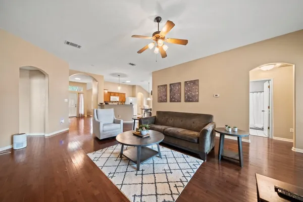 a living room with furniture and a wooden floor