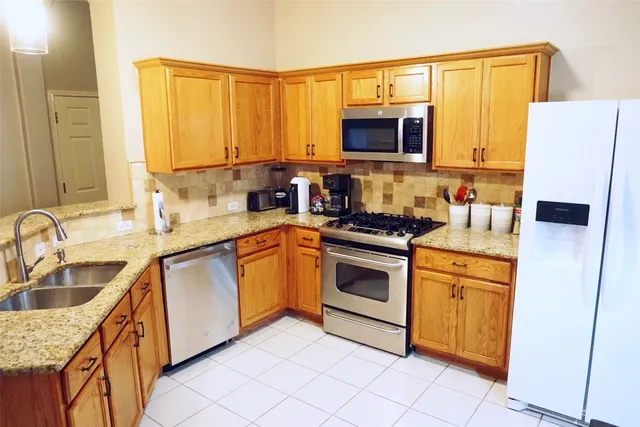 a kitchen with stainless steel appliances granite countertop a sink stove and microwave