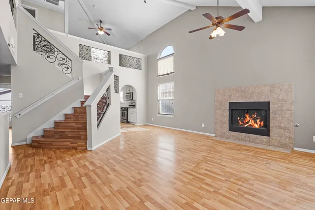 a view of empty room with wooden floor and fan