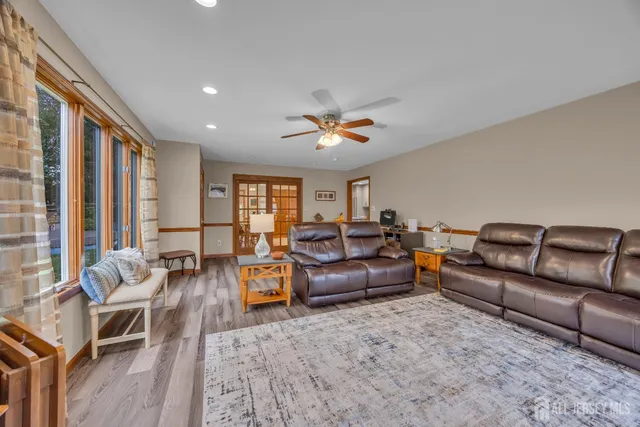 a living room with furniture a wooden floor and a large window