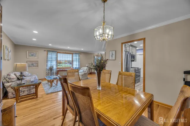 a living room with furniture two large window and a flat screen tv