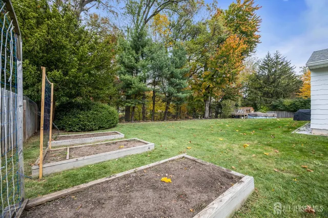 a white house with a small yard and a large tree