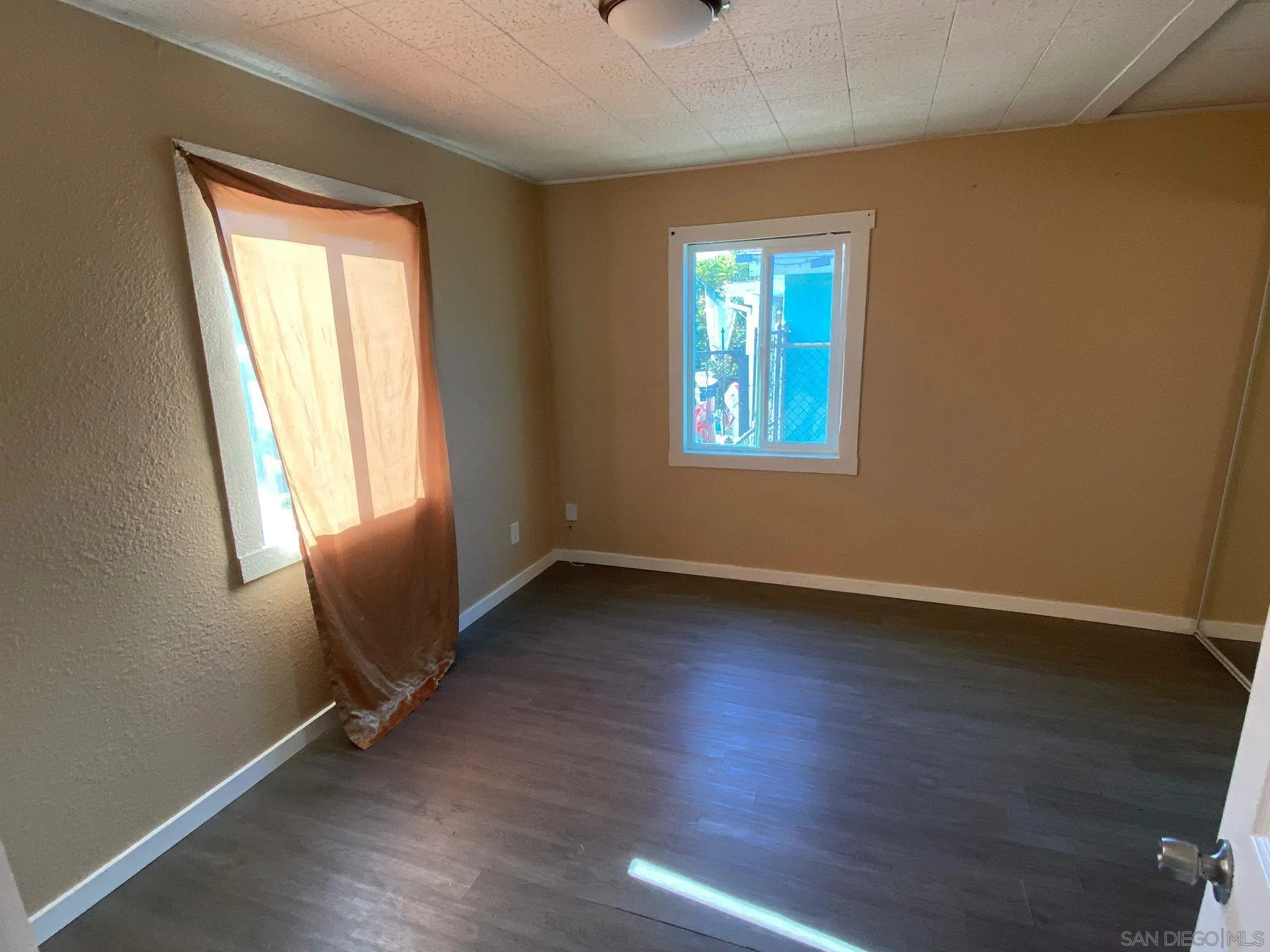 502 West 7th Avenue Escondido, CA 92025 - Photo 12 of 19 a view of an empty room with wooden floor and a window