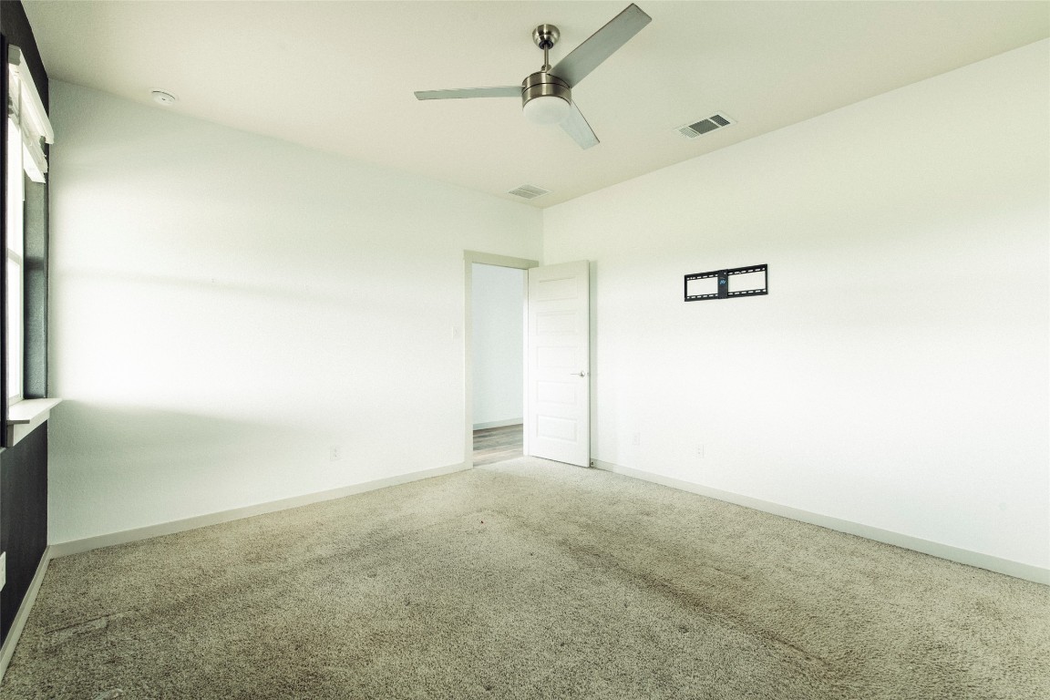 324 Millbrook Boulevard San Marcos, TX 78666 - Photo 18 of 29 an empty room with a ceiling fan and a window