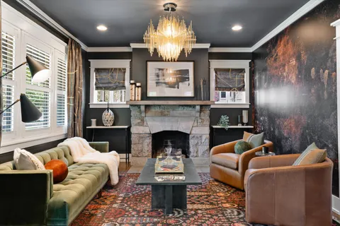 a living room with furniture a fireplace and a chandelier