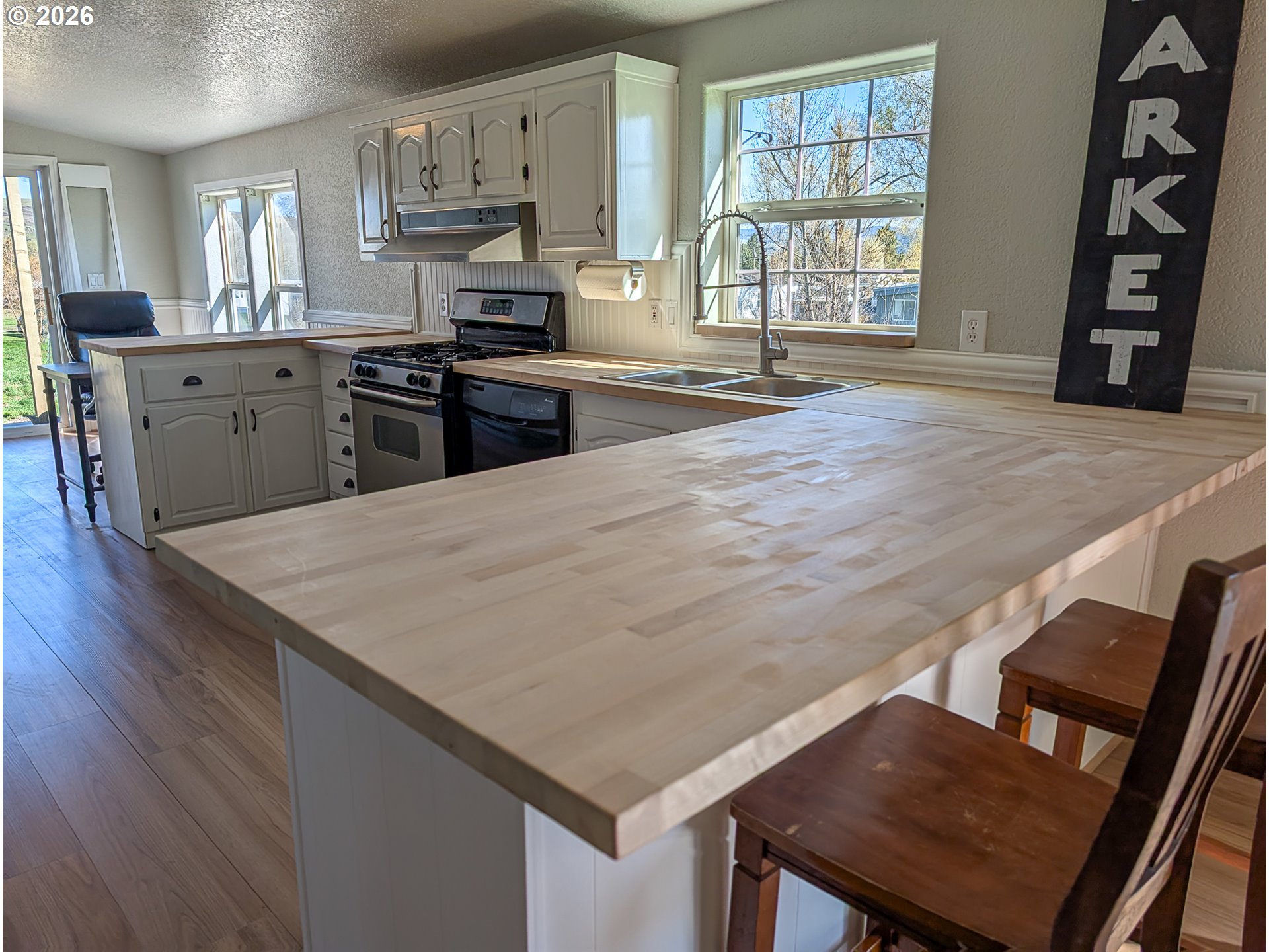 1670 Palmer Street Elgin, OR 97827 - Photo 14 of 41 a open kitchen with stainless steel appliances granite countertop a stove top oven a sink a dining table and chairs with wooden floor