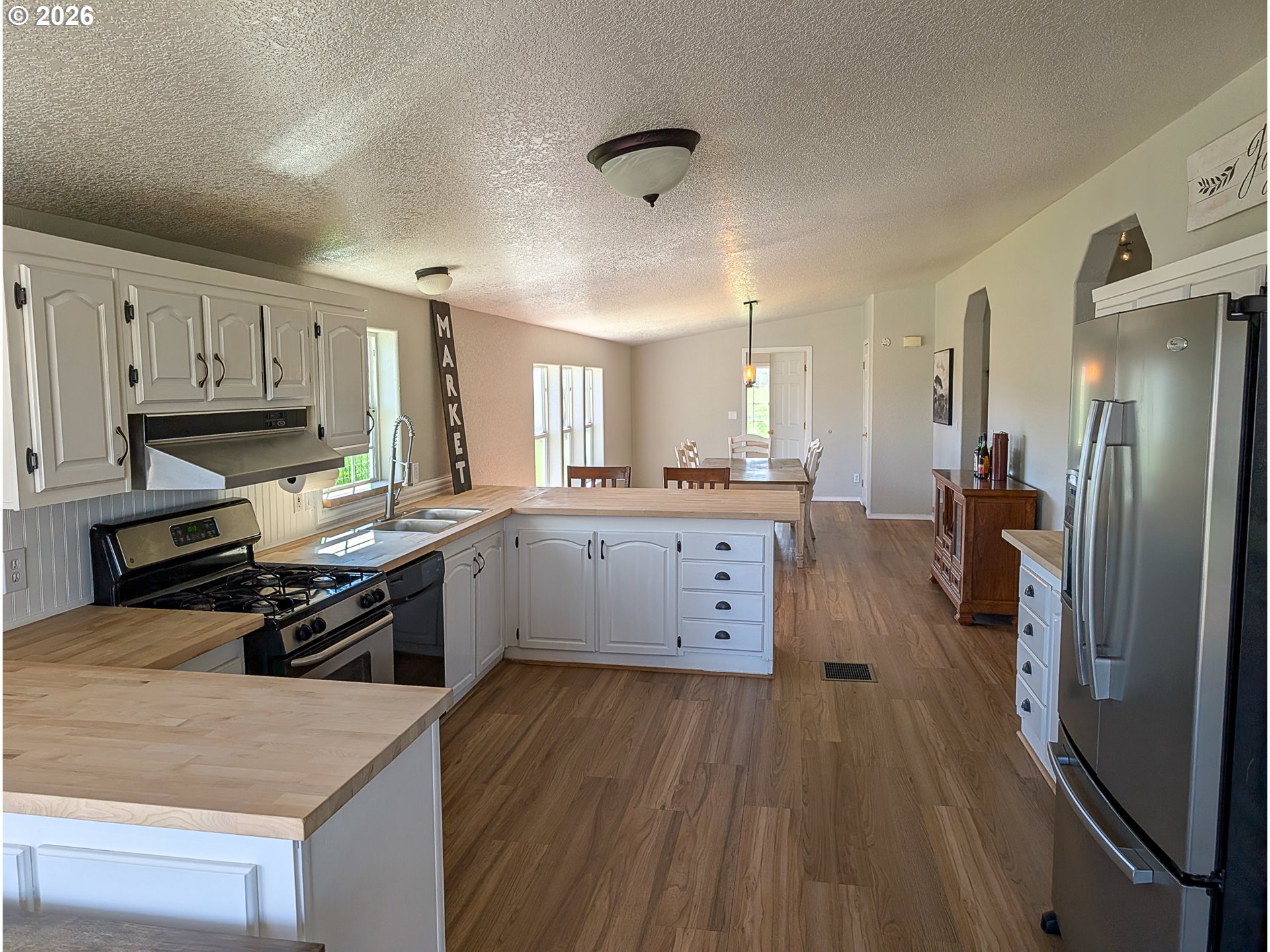 1670 Palmer Street Elgin, OR 97827 - Photo 17 of 41 a kitchen with stainless steel appliances granite countertop a stove a sink dishwasher a refrigerator and white cabinets with wooden floor
