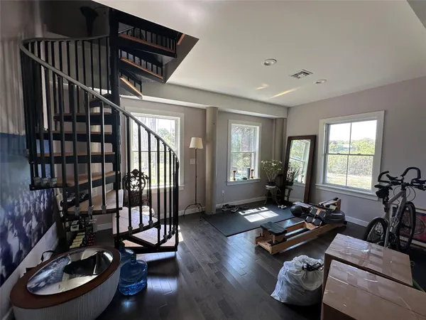 a living room with furniture a window and gym equipment