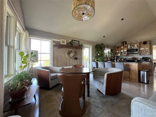 a living room with furniture a chandelier and a dining table