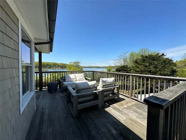 a balcony with wooden floor and outdoor seating