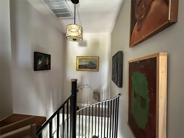 a view of a hallway with wooden floor and stairs