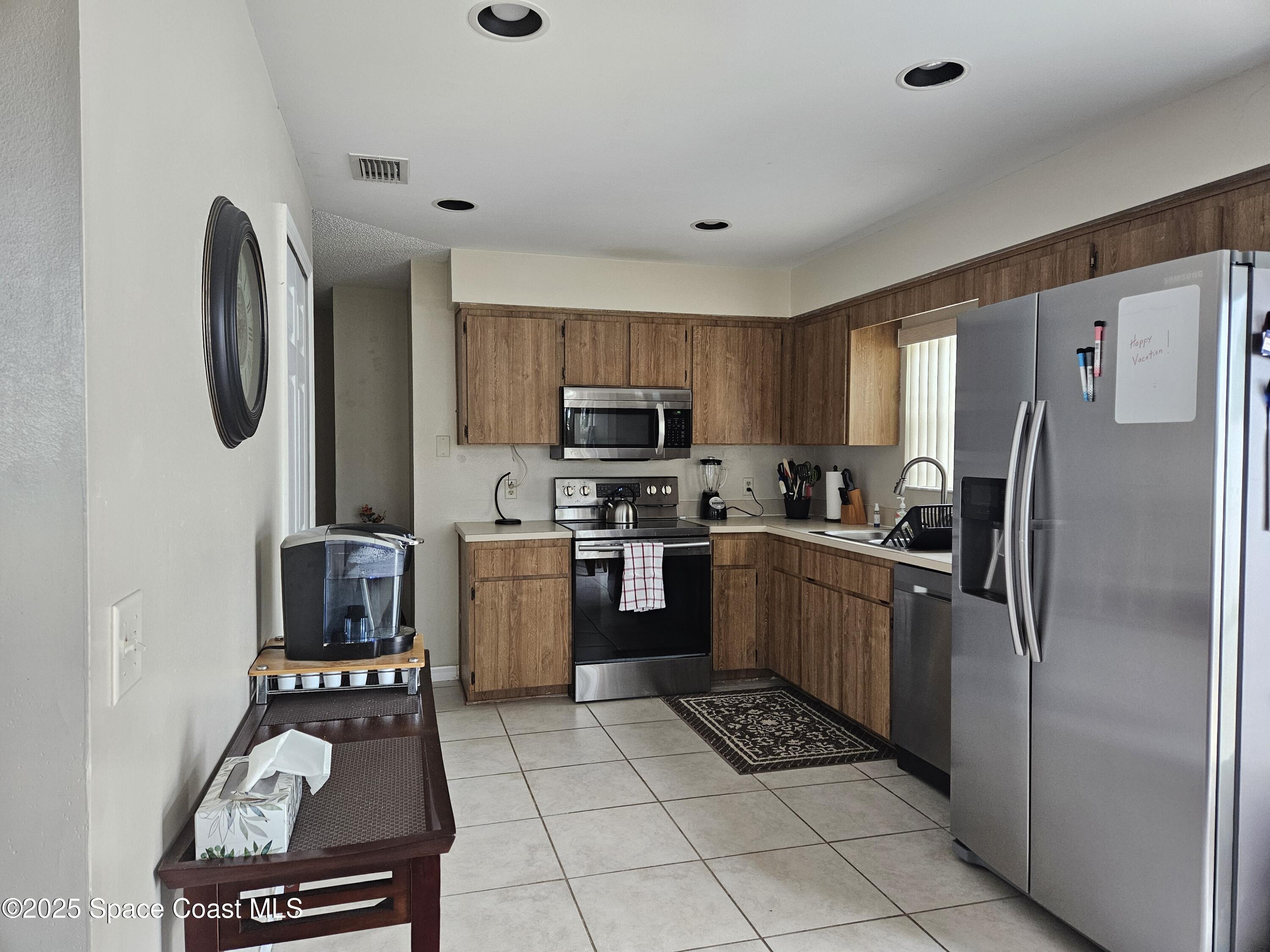 813 Pine Shadows Avenue Rockledge, FL 32955 - Photo 12 of 32 a kitchen with a refrigerator a stove top oven a sink and dishwasher
