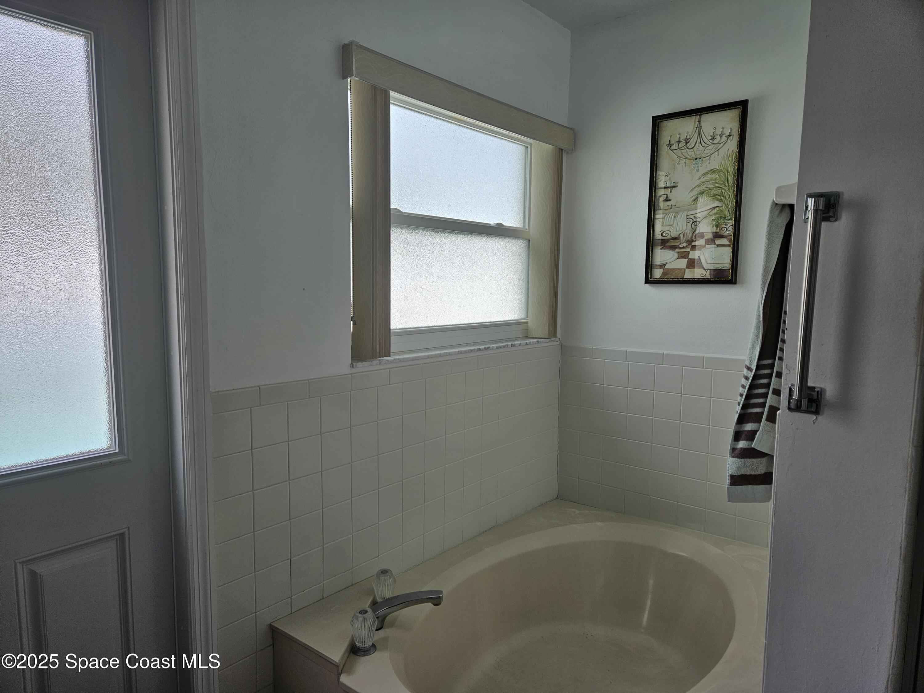 813 Pine Shadows Avenue Rockledge, FL 32955 - Photo 17 of 32 a bathroom with a tub and a window