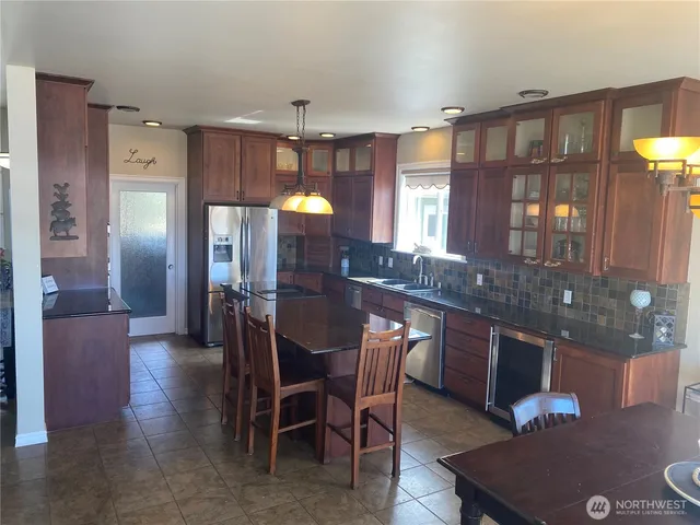 a kitchen with a dining table chairs and refrigerator