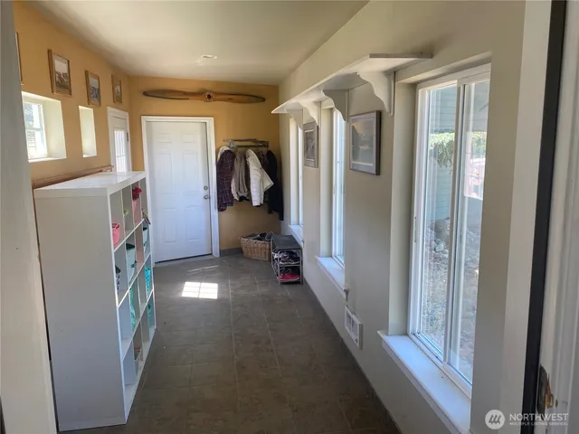 a view of a hallway with furniture and a window