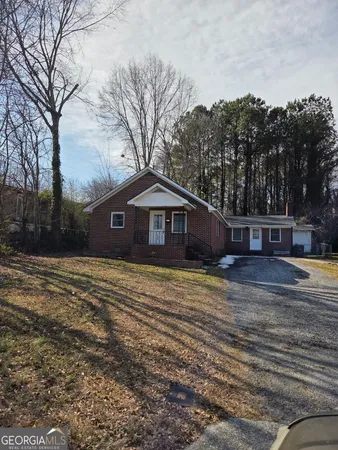 a front view of a house with a yard and trees