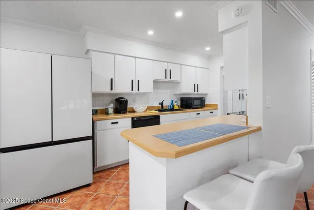 a kitchen with stainless steel appliances a refrigerator sink and white cabinets