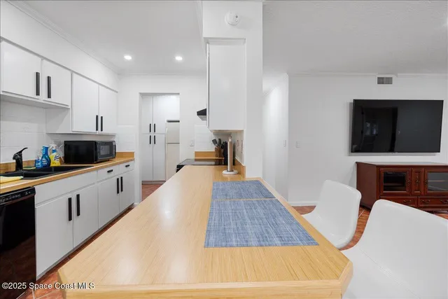 a large white kitchen with cabinets