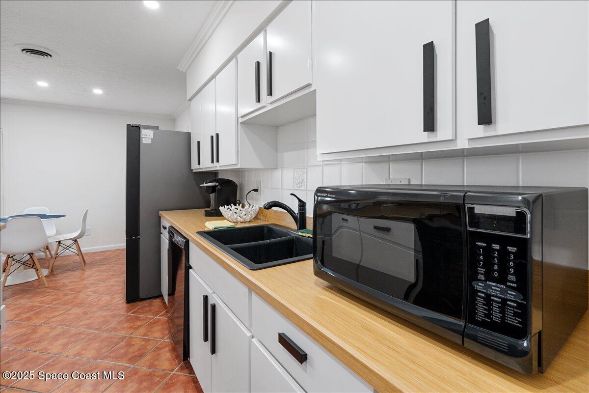 2175 Barracuda Avenue Melbourne Beach, FL 32951 - Photo 18 of 49 a kitchen with stainless steel appliances granite countertop a stove a sink and a microwave