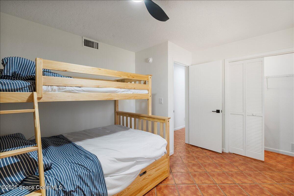 2175 Barracuda Avenue Melbourne Beach, FL 32951 - Photo 25 of 49 a bedroom with a bed and cabinets