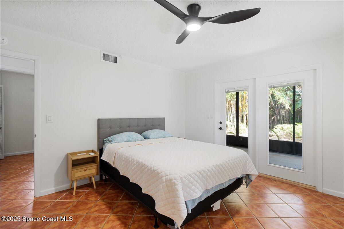 2175 Barracuda Avenue Melbourne Beach, FL 32951 - Photo 27 of 49 a bedroom with a bed and a chandelier