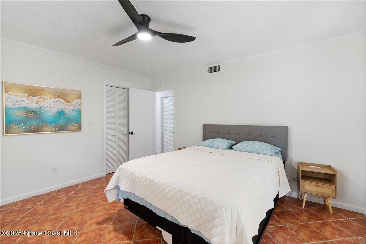 2175 Barracuda Avenue Melbourne Beach, FL 32951 - Photo 28 of 49 a bedroom with a bed and a chair