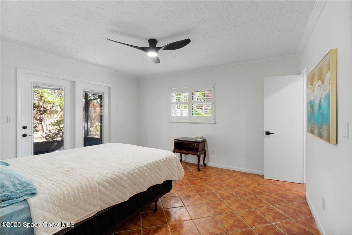 2175 Barracuda Avenue Melbourne Beach, FL 32951 - Photo 31 of 49 a bedroom with a bed and a chandelier