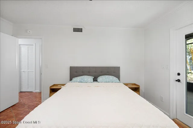 a bedroom with a white bed and a night stand