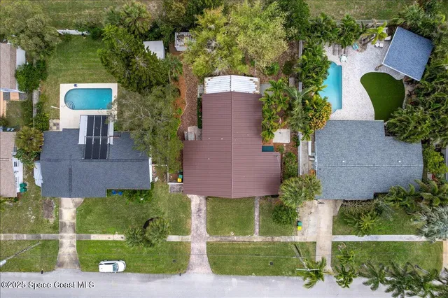 front view of house with a yard and potted plants