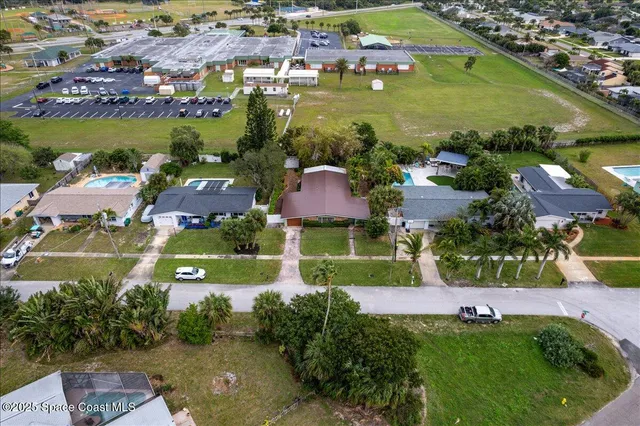 an aerial view of residential houses with outdoor space and lake view