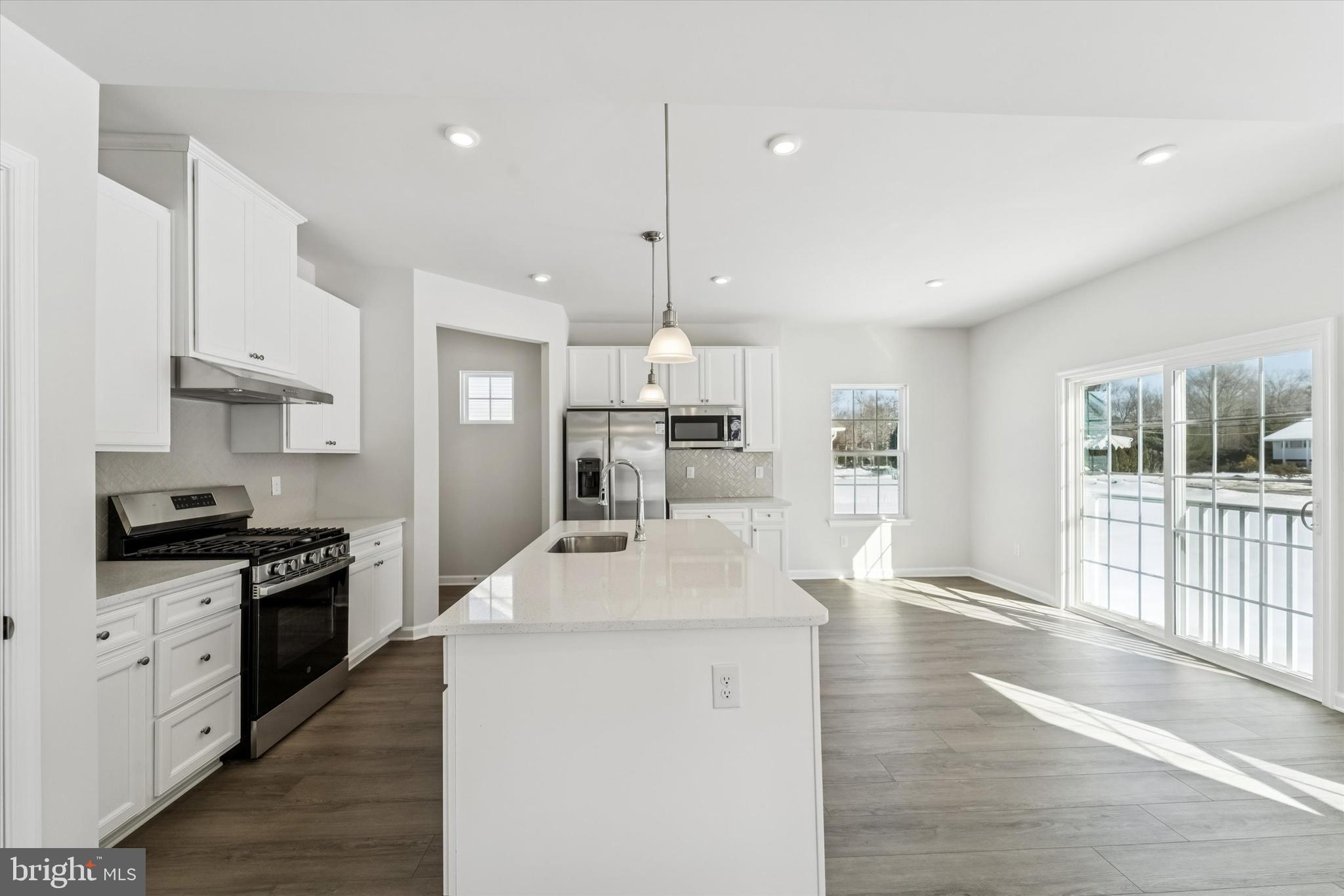 56 Mockernut Road Williamstown, NJ 08094 - Photo 5 of 29 a kitchen with stainless steel appliances kitchen island granite countertop a stove a sink a refrigerator and white cabinets with wooden floor