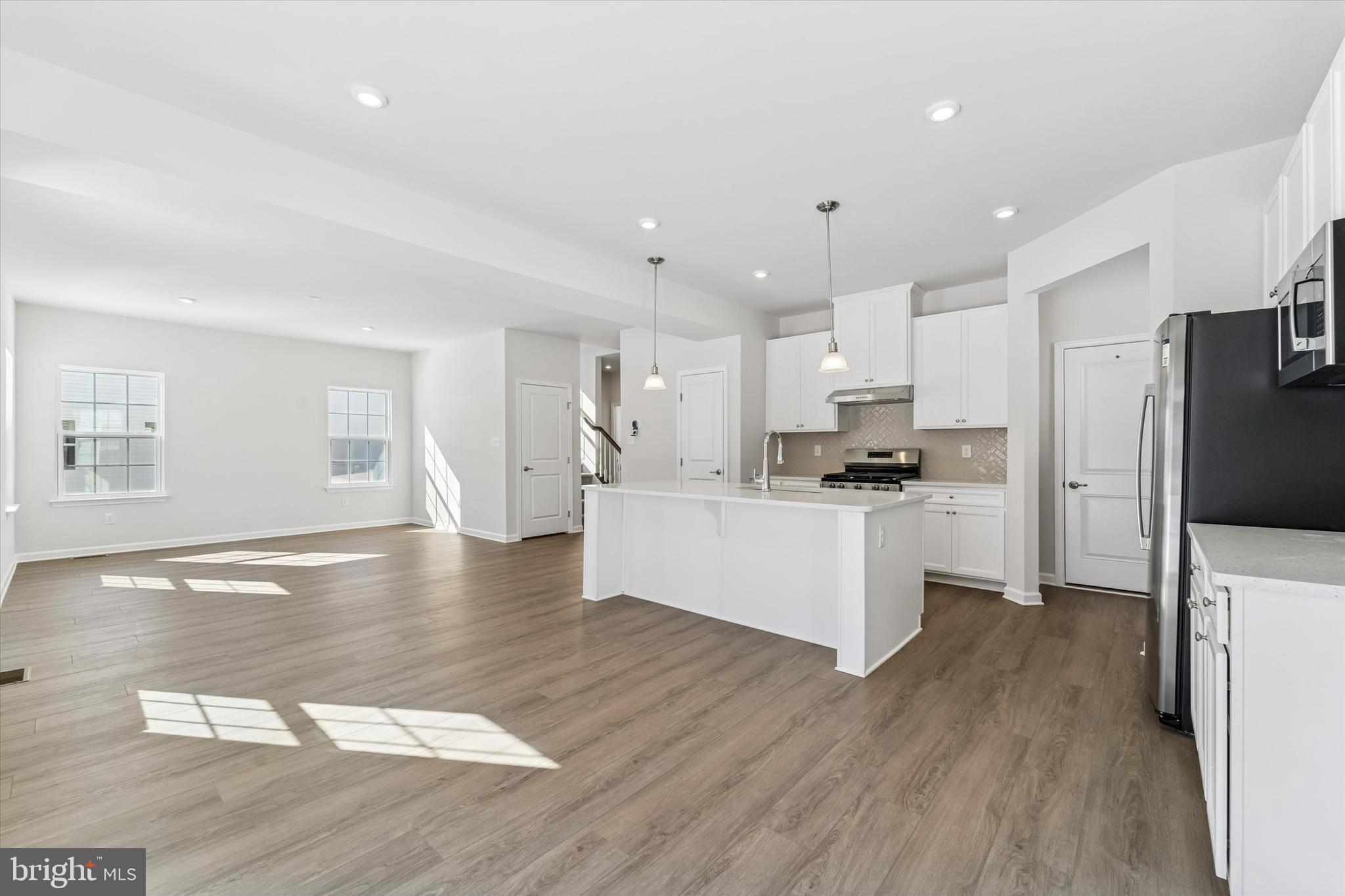 56 Mockernut Road Williamstown, NJ 08094 - Photo 8 of 29 a kitchen with stainless steel appliances kitchen island granite countertop a stove a refrigerator a sink a stove and white cabinets with wooden floor