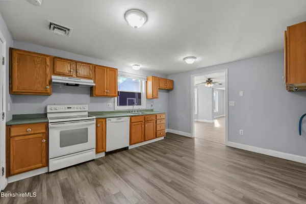 a kitchen with stainless steel appliances granite countertop a stove a sink and a refrigerator