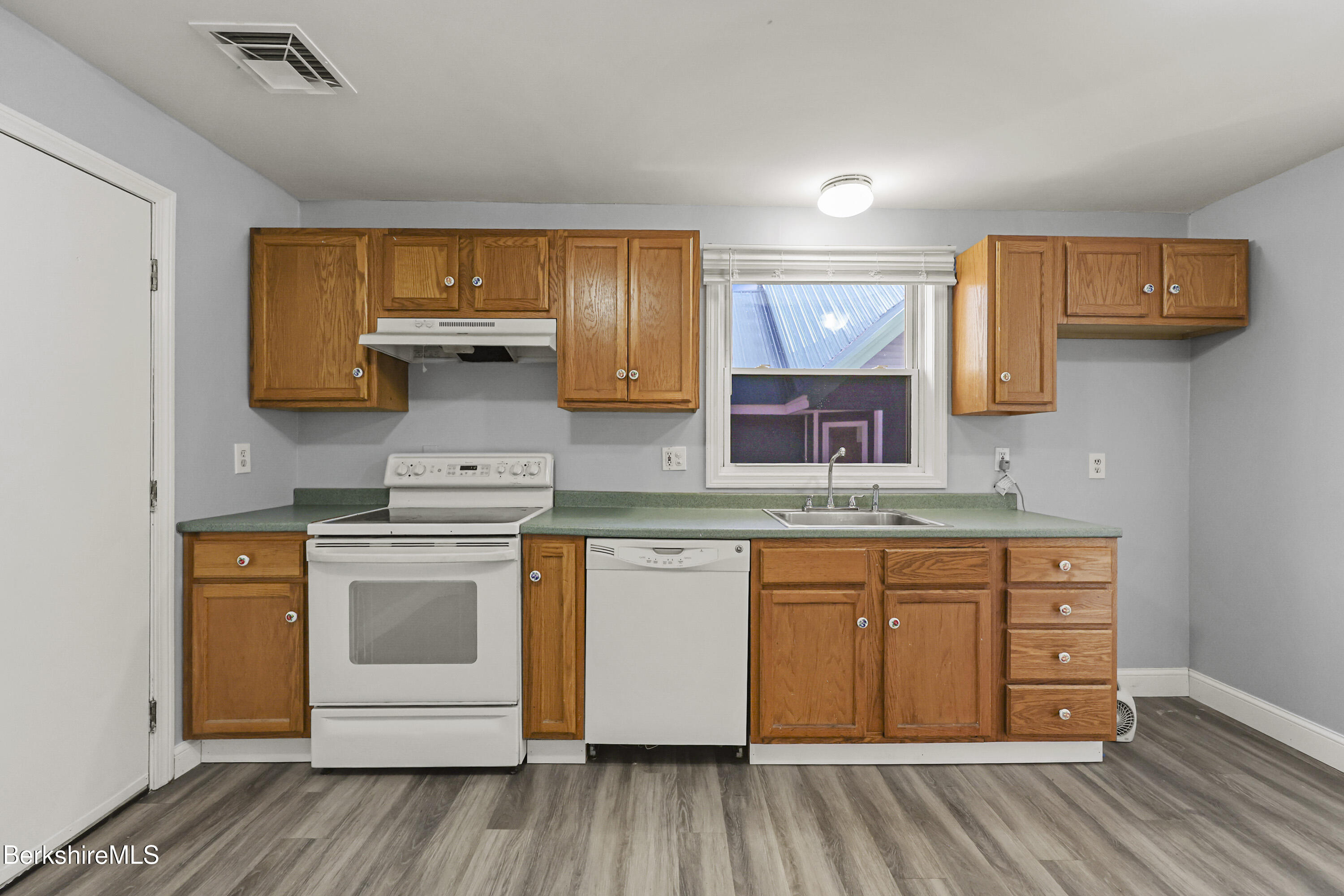 73-75 Hall Street North Adams, MA 01247 - Photo 13 of 32 a kitchen with stainless steel appliances granite countertop a sink stove and wooden cabinets