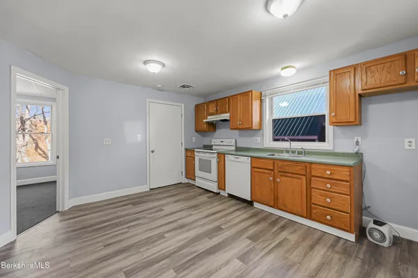 a kitchen with stainless steel appliances granite countertop a sink cabinets and wooden floor