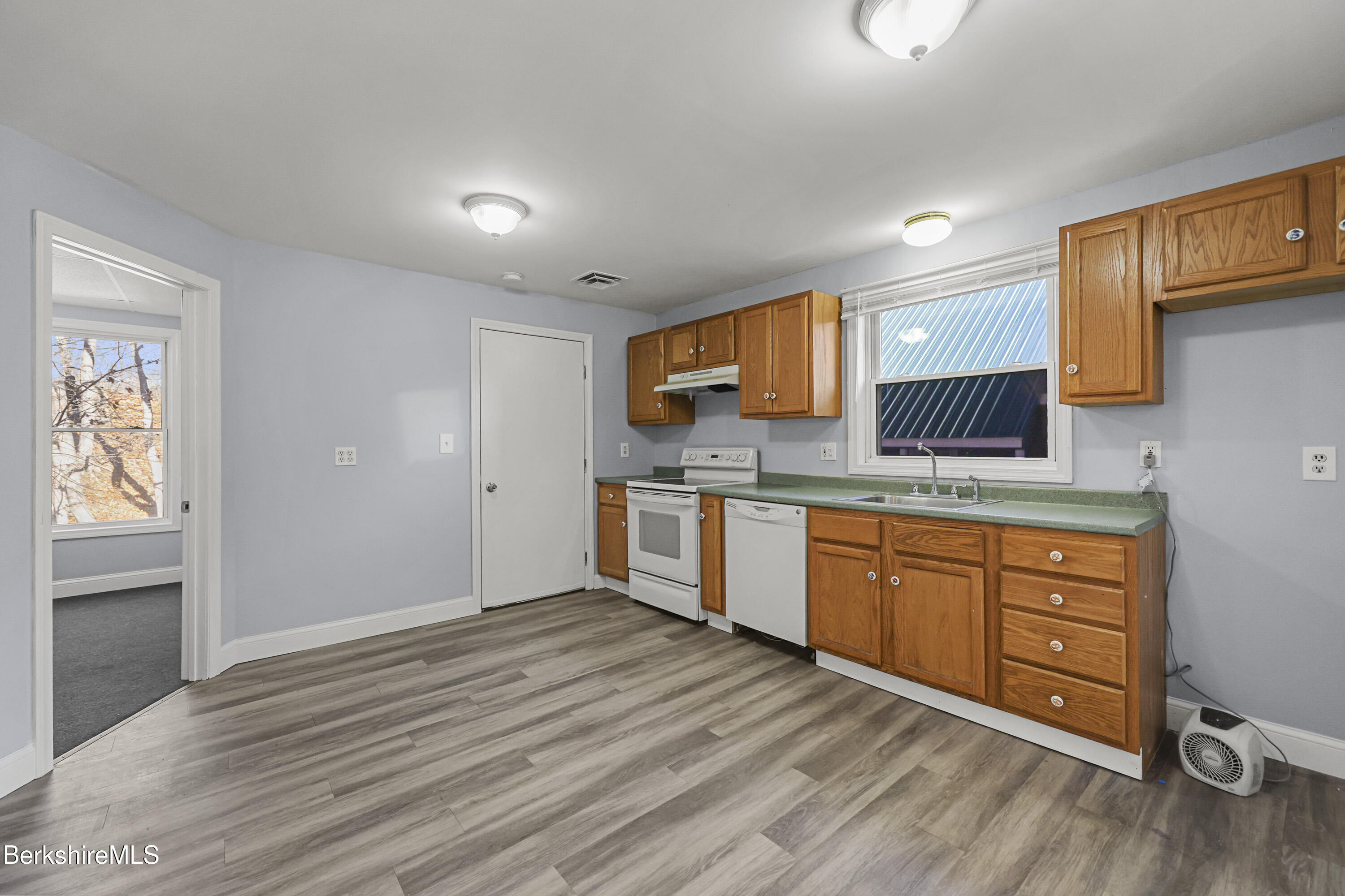 73-75 Hall Street North Adams, MA 01247 - Photo 15 of 32 a kitchen with stainless steel appliances granite countertop a sink cabinets and wooden floor