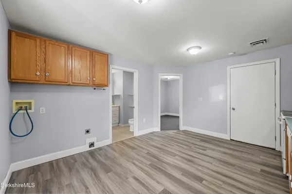 a view of a room with wooden floor and cabinets