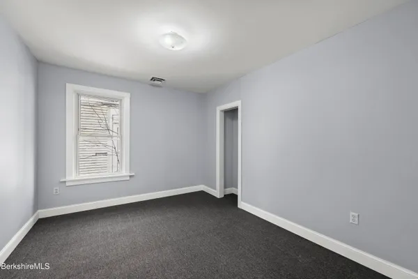 an empty room with windows and closet