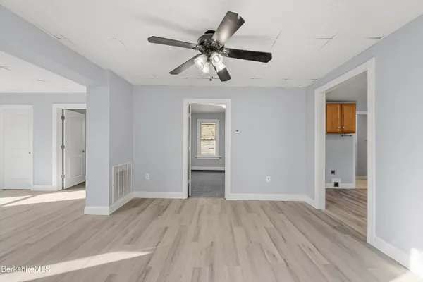 a view of empty room with wooden floor