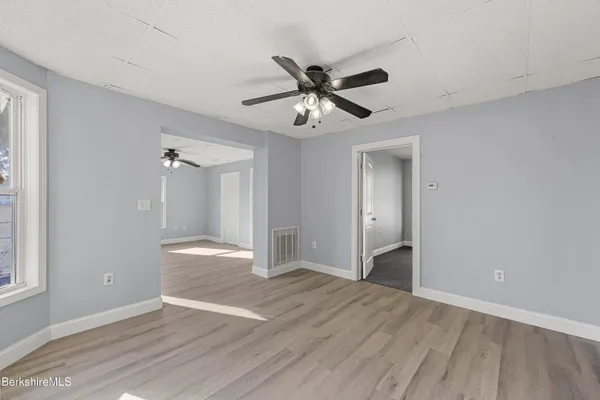 a view of an empty room and window and wooden floor