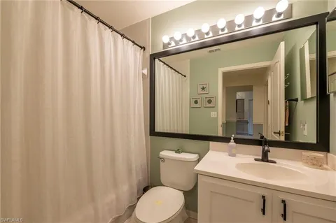 a bathroom with a toilet a sink and a mirror