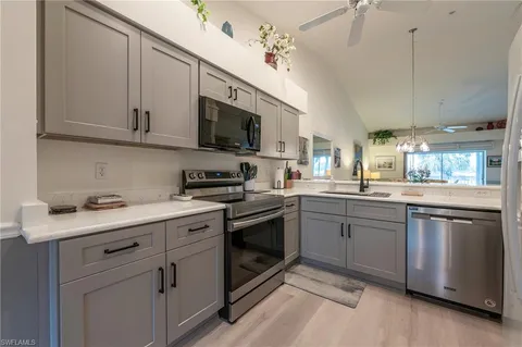 a kitchen with a sink stainless steel appliances and white cabinets