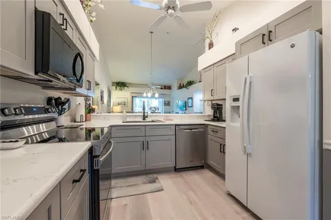 a kitchen with stainless steel appliances a sink a stove a refrigerator cabinets and a counter top space
