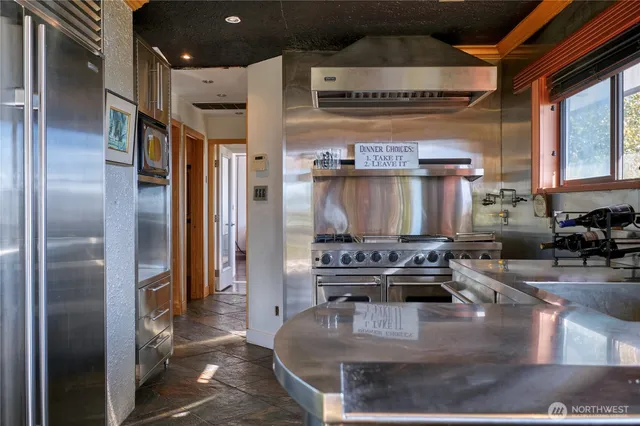 a kitchen with stainless steel appliances granite countertop a stove refrigerator and cabinets