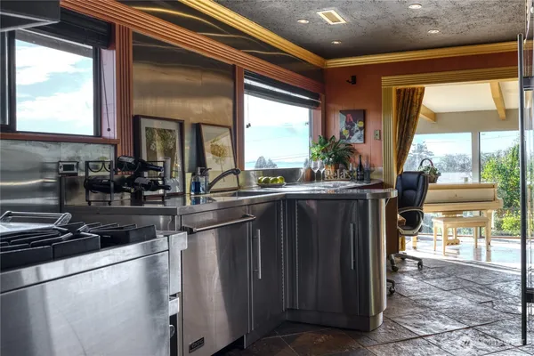 a kitchen with sink and large windows