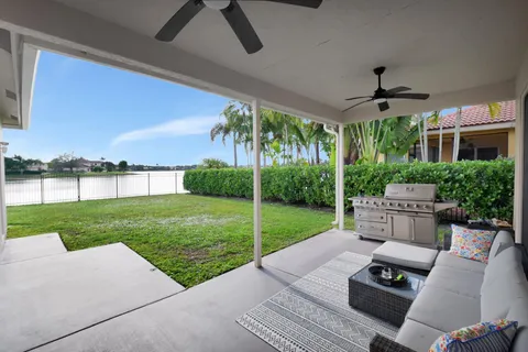 a view of a patio with couches plants and a big yard