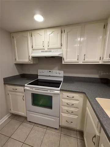 a kitchen with granite countertop a refrigerator and a sink